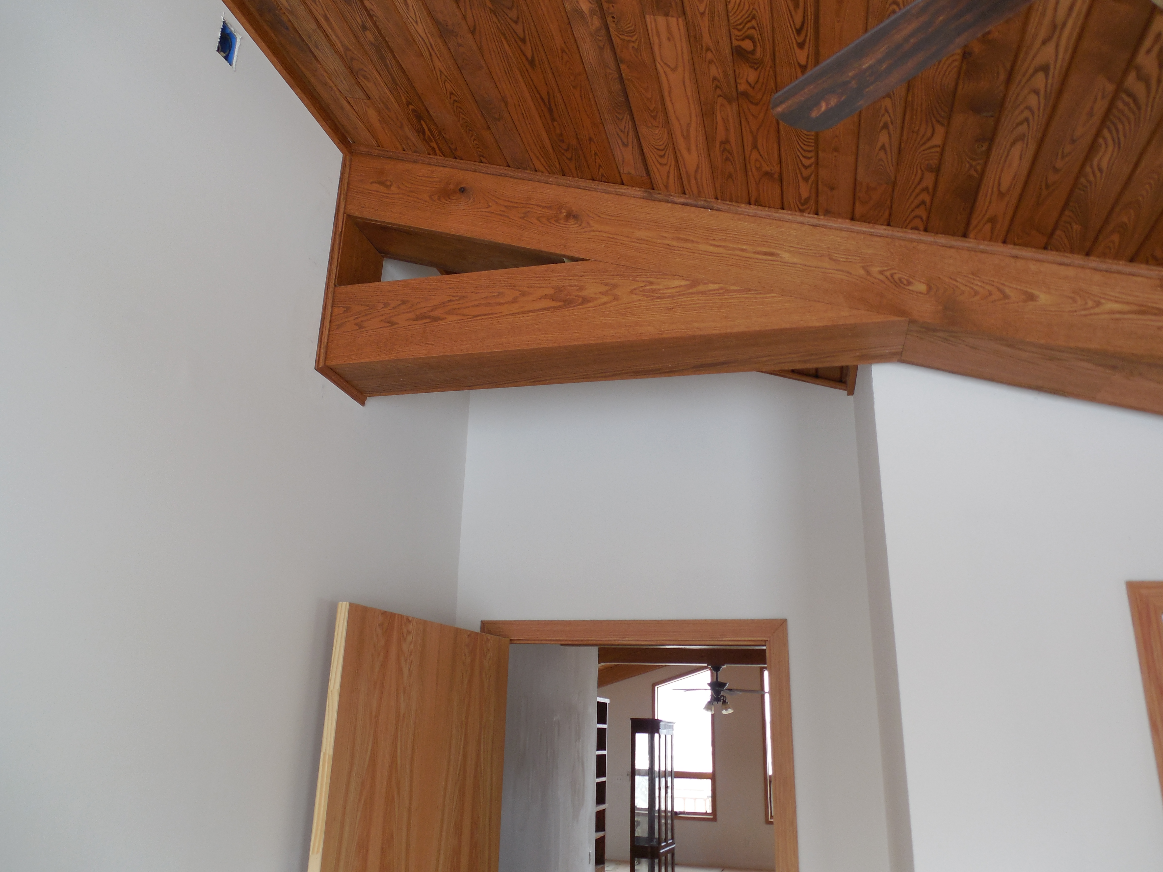 Wood covered beam in bedroom